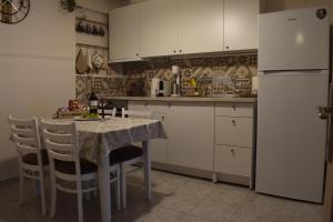 a kitchen with a table with chairs and a refrigerator at Floor in Alexandroupoli