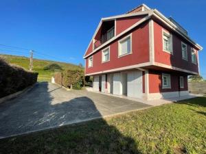 a red and white house sitting on top of a field at Casa - Chalet en Barizo - Malpica de Bergantiños in A Coruña