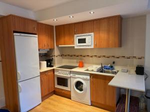 a kitchen with a white refrigerator and a dishwasher at Apartamento La Calma in Fiscal