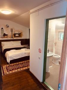 a bedroom with a bed and a bathroom with a toilet at B&B Maria in Bucharest