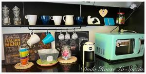 a kitchen counter with a microwave and some cups at Dodo House La Spezia in La Spezia