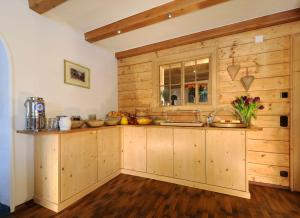 a kitchen with wooden cabinets and a window at Haus Küng in Zürs am Arlberg