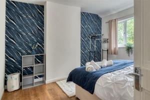a bedroom with a bed with a blue blanket at Full House, Massage Mattresses, Sleeps 6 guests, Free wifi, Free Parking, Free Netflix, Smart TV in Manchester
