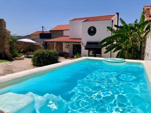 a large blue swimming pool in front of a house at Pool oasis with private parking -Vigia 8 in Torres Vedras