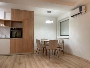a kitchen and dining room with a table and chairs at Ruby Modern Central Apartment in Skopje +12 photos