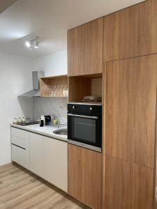a kitchen with white cabinets and a black oven at Ruby Modern Central Apartment in Skopje