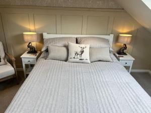 a bedroom with a bed with a deer pillow on it at Kirkton Rest in Cardross