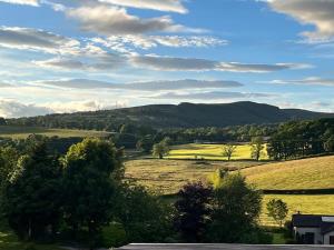 a view of a field with trees and mountains at Kirkton Rest in Cardross
