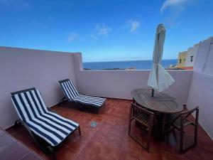 ein Balkon mit Tisch und Stühlen und dem Meer in der Unterkunft Estudio con terraza in La Caleta