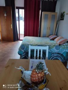 eine Ananas auf einem Tisch in einem Zimmer mit einem Bett in der Unterkunft Estudio con terraza in La Caleta