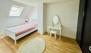 a bedroom with a bed and a dressing table with a mirror at Grand Duplex à 400m de la plage in Saint-Aubin-sur-Mer