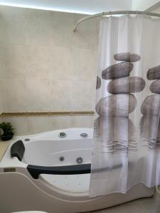 a bathroom with a bath tub with a shower curtain at Seascape apartment in Larnaca +39 photos