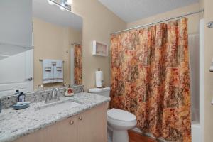 a bathroom with a toilet and a shower curtain at SunnyPeace Retreat in The Villages +12 photos