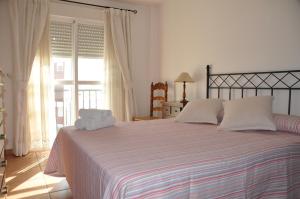 una camera da letto con un grande letto con due asciugamani di Casa Rojas a Tarifa