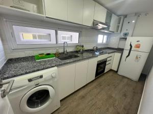 a kitchen with a washing machine and a refrigerator at Rivadavia Confort in Mariano J. Haedo