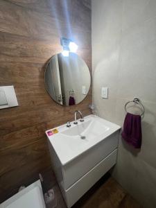 a bathroom with a white sink and a mirror at Rivadavia Confort in Mariano J. Haedo +8 photos
