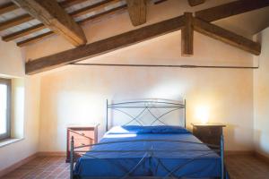 ファーノにあるVilla Rinolfaの木製の天井のベッドルームで、青いベッド1台が備わります。