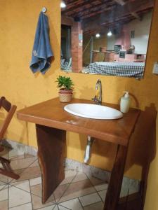 ein Badezimmer mit Waschbecken und Spiegel in der Unterkunft Chalé Vitória 1- Rancho dos 7 in Arapeí