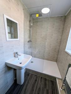 a bathroom with a white sink and a shower at Spacious Large Flat For Your Family And Friends in Gateshead