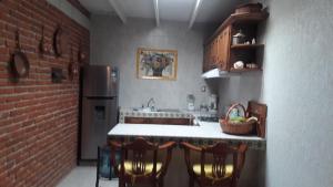 a kitchen with a table and some chairs and a brick wall at Casa Müi in Tequisquiapan