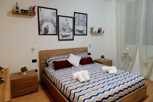 a bed in a bedroom with pictures on the wall at MJ Venice Guest House in Marghera +22 photos