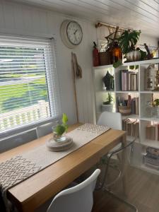 a dining room table with chairs and a clock on the wall at The Van in Porchfield +7 photos