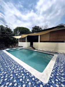 a swimming pool in front of a house at Rancho Bonito - Rest & Reset in Tamanique