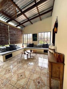 a large living room with couches and tables and windows at Rancho Bonito - Rest & Reset in Tamanique