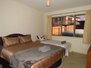 a bedroom with a bed and a large window at Cleggs Batch in Karikari Peninsula