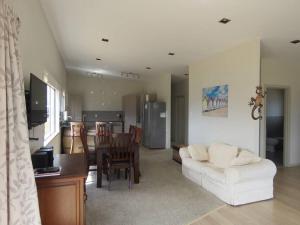 a living room with a white couch and a table at Cleggs Batch in Karikari Peninsula