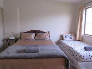 a bedroom with a large bed and a window at Cleggs Batch in Karikari Peninsula