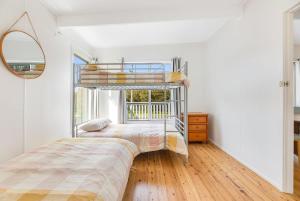 a bedroom with two bunk beds and a window at 52 Ballingalla Street, Narooma in Narooma