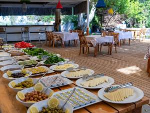 a table filled with plates of food on a wooden table at Hotel Gumusluk in Gümüşlük