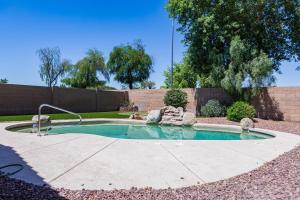 a small pool with a fountain in a yard at Sun-Kissed Gem - Pool Heater Golf Green AZ Room in Peoria