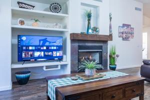 a living room with a tv and a fireplace at Sun-Kissed Gem - Pool Heater Golf Green AZ Room in Peoria