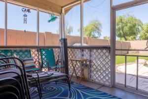 a screened porch with chairs and a table at Sun-Kissed Gem - Pool Heater Golf Green AZ Room in Peoria