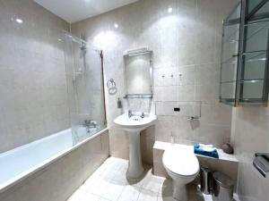 a bathroom with a sink and a toilet and a tub at Little House on 2e Rue for tourists in Chapais