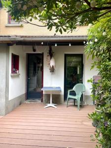 a porch with a table and a chair on a house at Maison proche Paris Stade de France in Aubervilliers