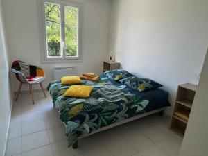 a bedroom with a bed and a chair and a window at La maison du Chef in Le Blanc