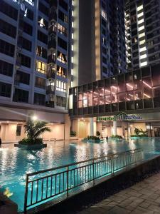 a large swimming pool in a city at night at Bali Residence Impian Raudah in Melaka