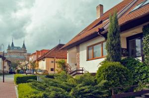 a house on a street with a building in the background at Dom pod zámkom in Bojnice