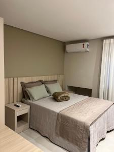 a bedroom with a large bed with a night stand at Apto 12 - Suíte Família Próx Paraguai in Foz do Iguaçu