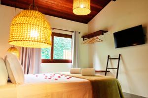 a bedroom with a bed and a chandelier at Tropicália Chalés Boutique in Pipa