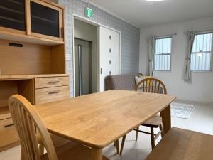 a kitchen and dining room with a wooden table and chairs at AMP FLAT Tosu in Tosu