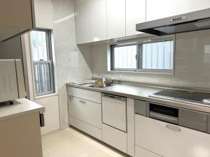 a kitchen with white cabinets and a stove top oven at AMP FLAT Tosu in Tosu