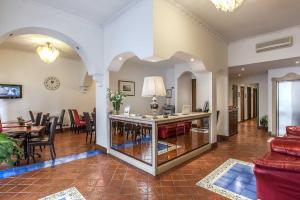ein Wohnzimmer mit einem Tisch und einem Esszimmer in der Unterkunft Hotel Caracciolo in Rom