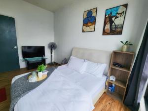 a bedroom with a white bed and a television at Studio E Sofo Apartment Suria Jaya -Shah Alam in Shah Alam +9 photos