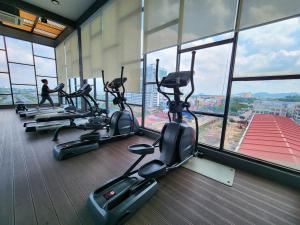 a row of treadmills in a gym with windows at Studio E Sofo Apartment Suria Jaya -Shah Alam in Shah Alam