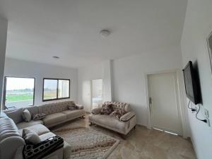 a living room with couches and a flat screen tv at Guest house in Ghawr alsafi in Aş Şāfī
