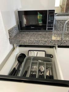 a kitchen counter with a sink with a microwave at Residencial Málaga 02 in Sinop +21 photos